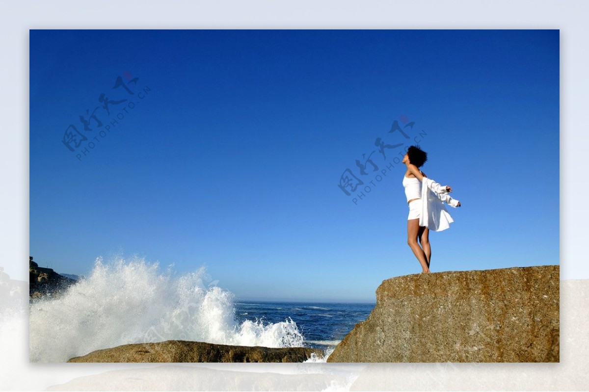 海边岩石享受生活的贵妇图片