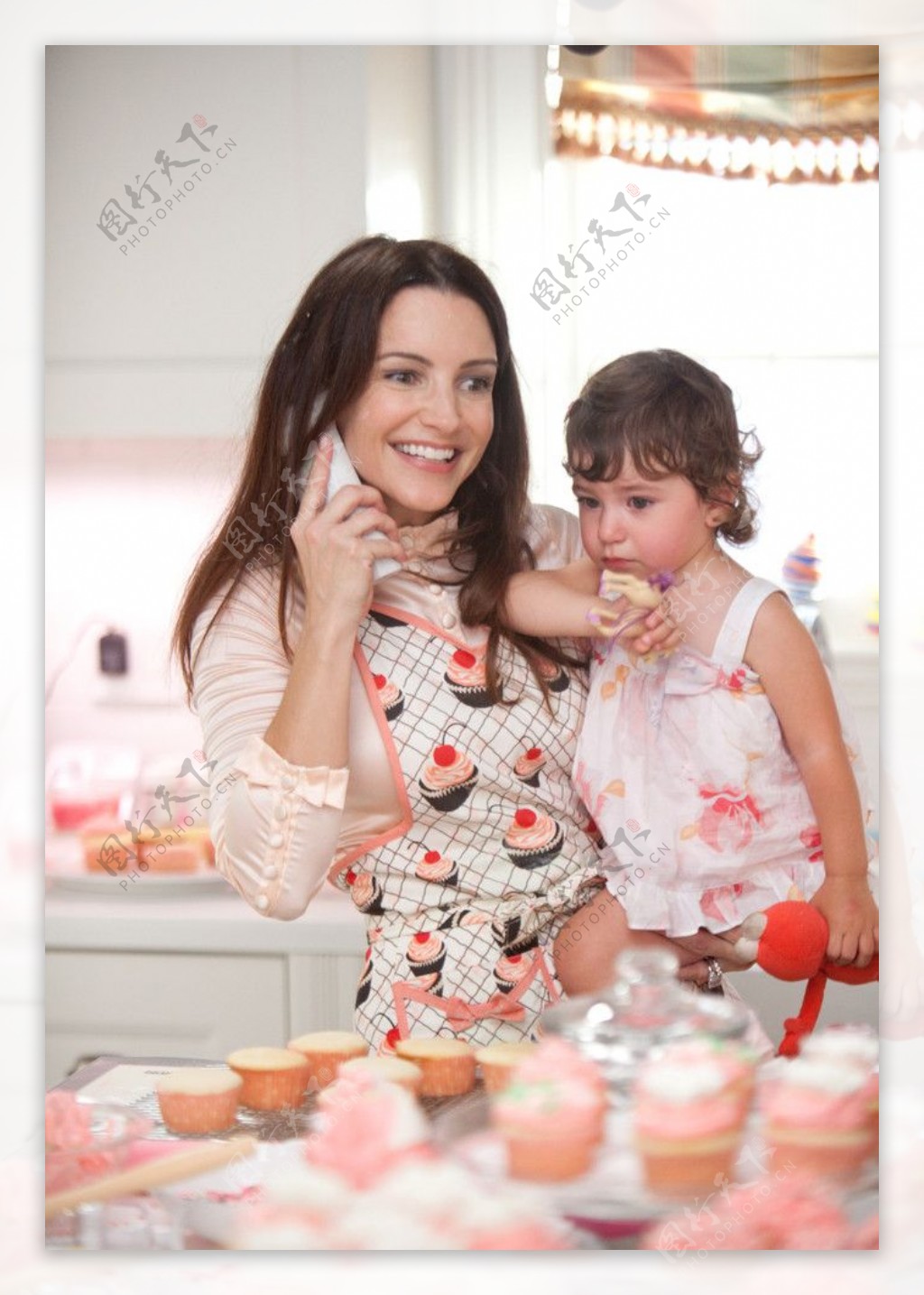 美女妈妈抱着孩子在蛋糕店购物图片