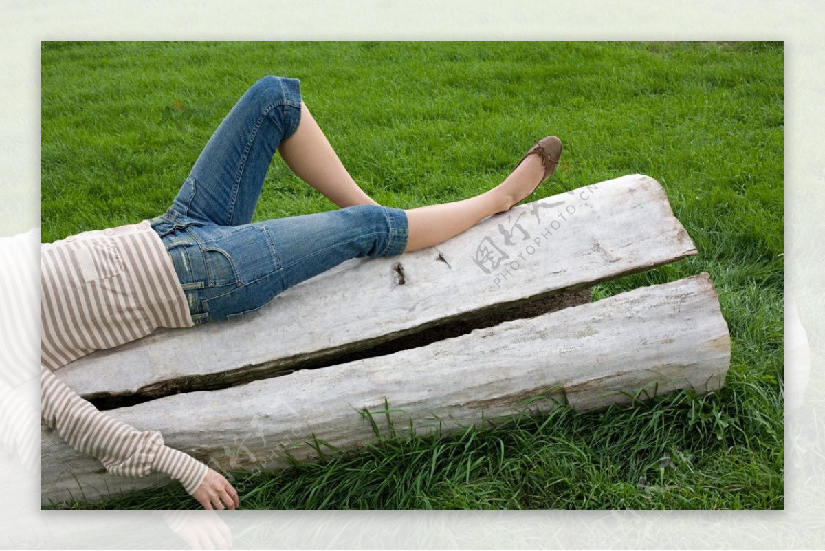 草地枯木上躺着休息的女孩性感美腿图片