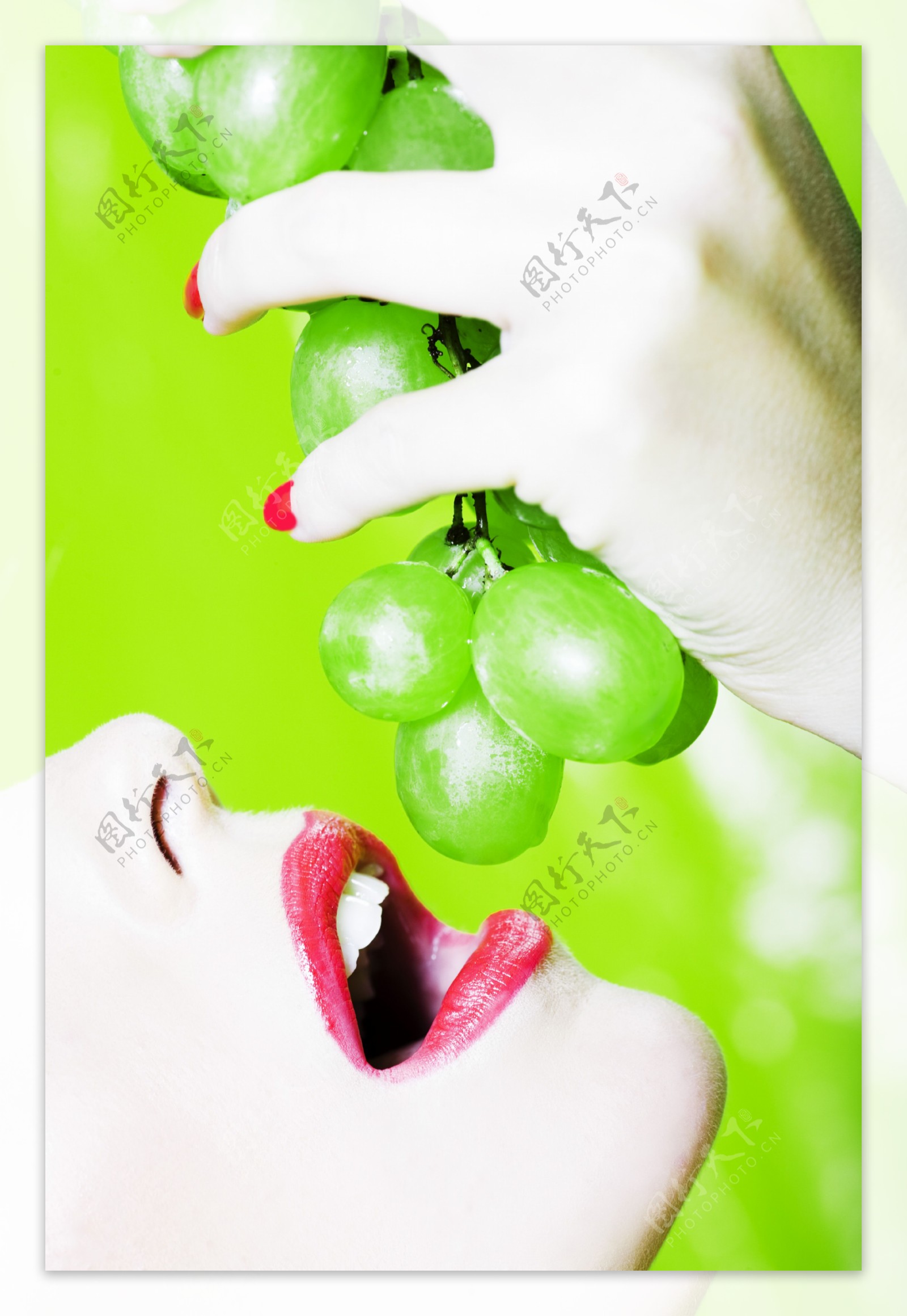 拿着一串葡萄张嘴吃的女人图片
