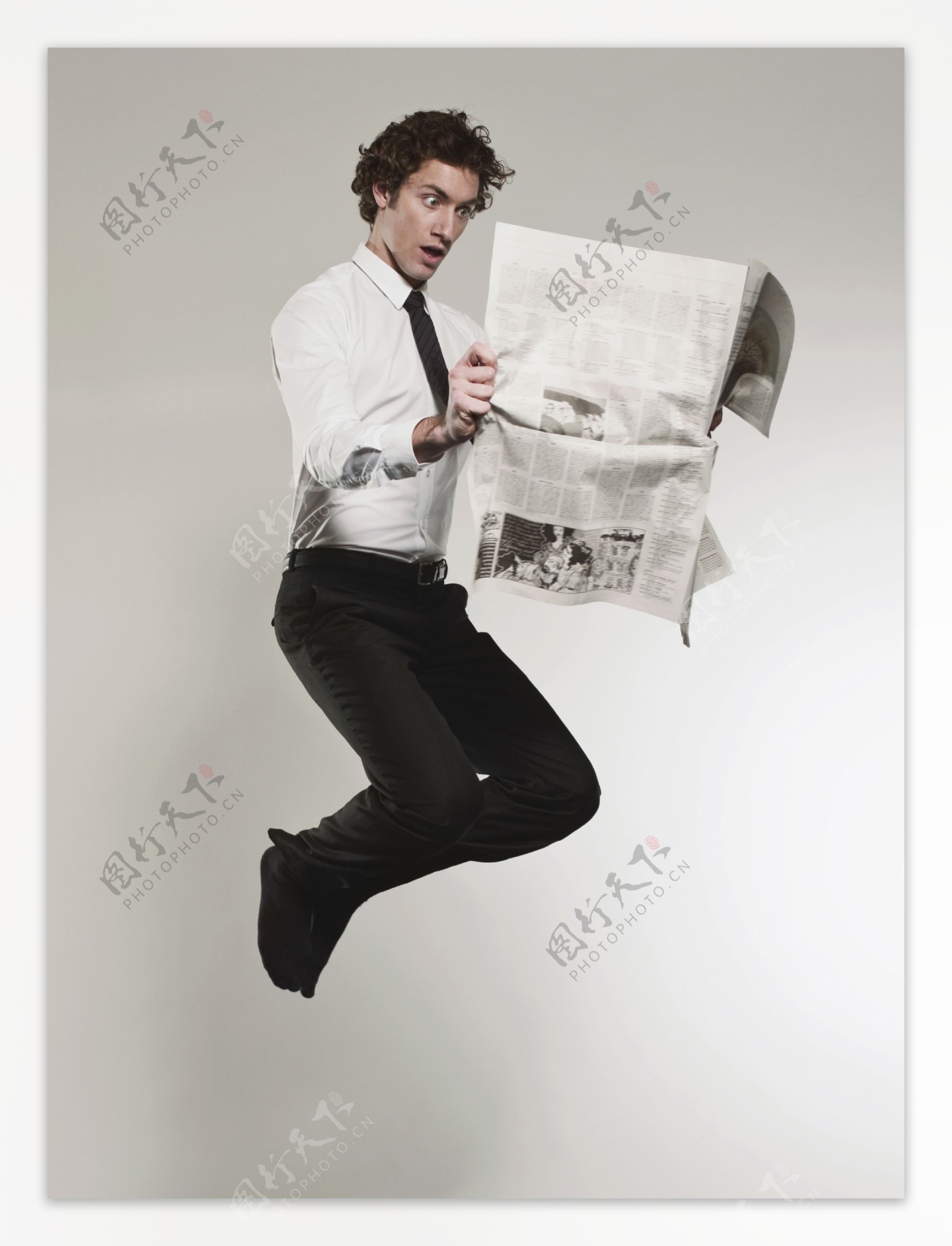 看报纸时激动跳跃的外国男性图片