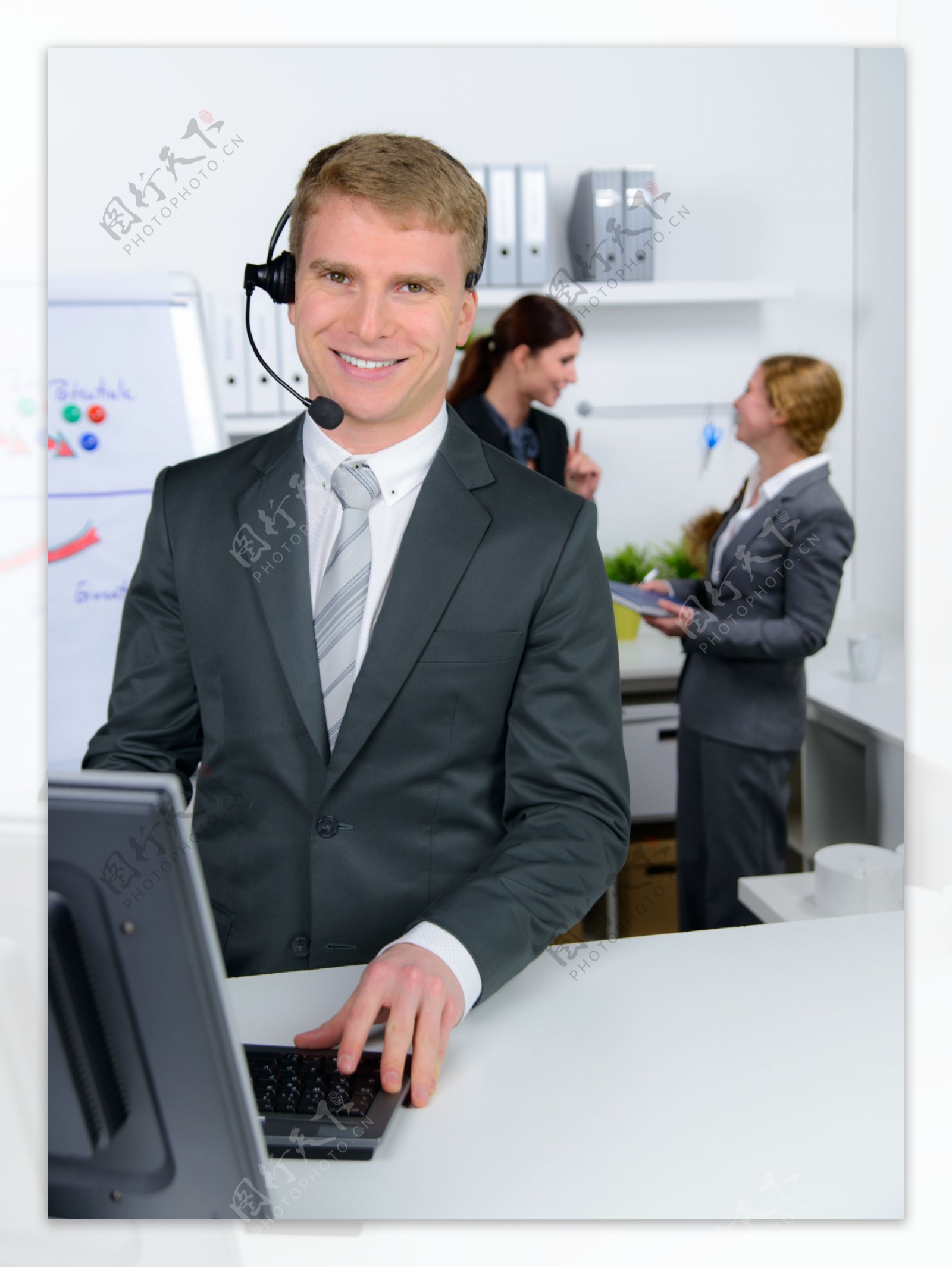 戴耳麦打电脑的商务男人图片