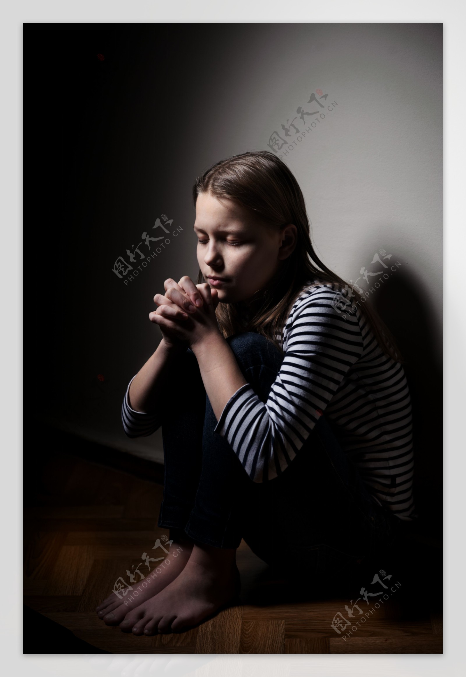 坐在地上祈祷的女孩图片