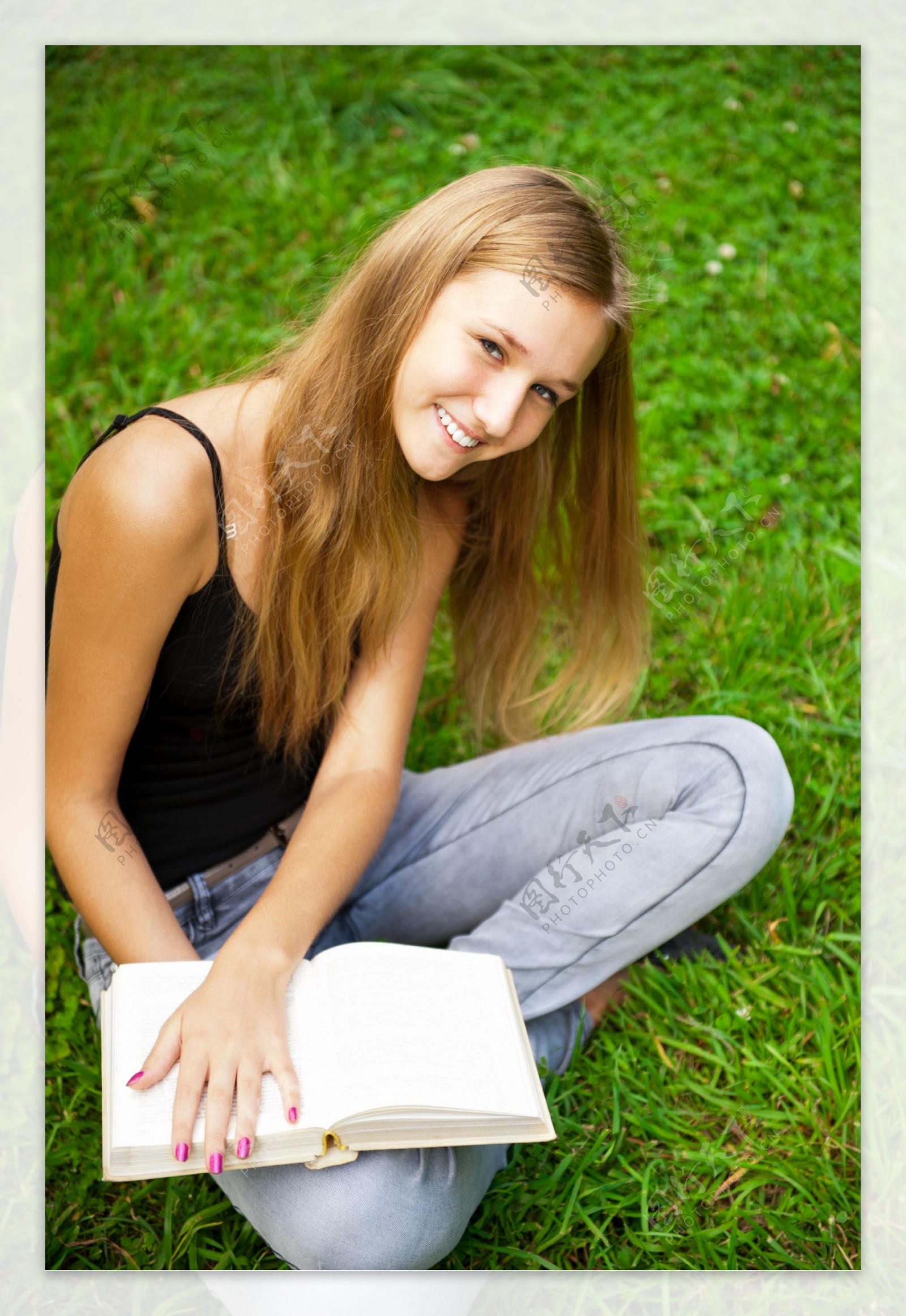 坐在草地上看书的外国女孩图片