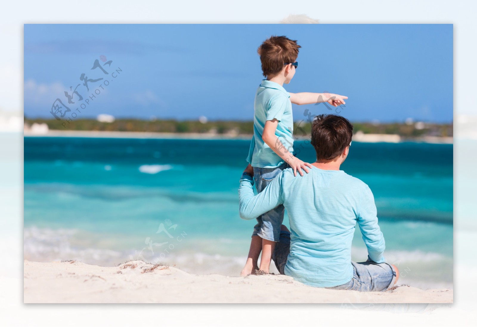 坐在沙滩上看海的外国爸爸和孩子图片