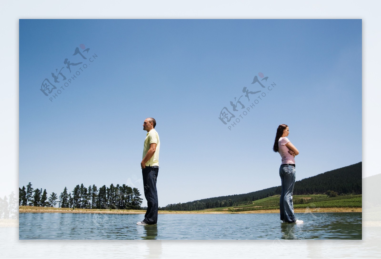 背靠背站立在水面的男女图片