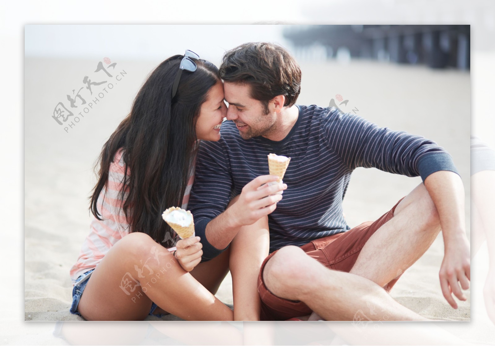 沙滩上吃甜筒的情侣图片