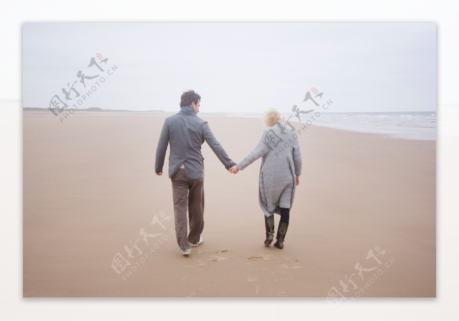 牵手走在沙滩上的情侣背影图片