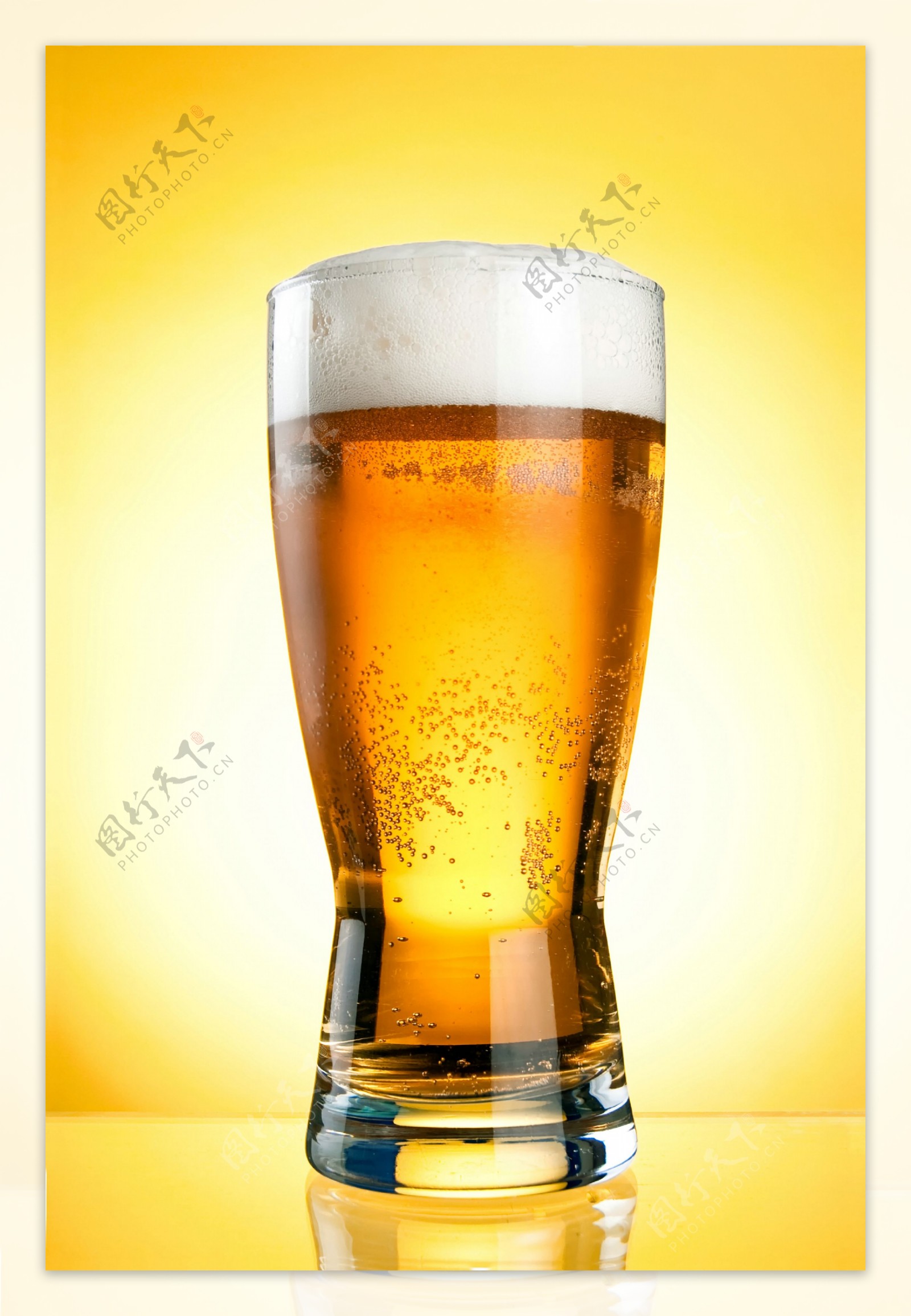 黄色背景前的一玻璃杯啤酒
