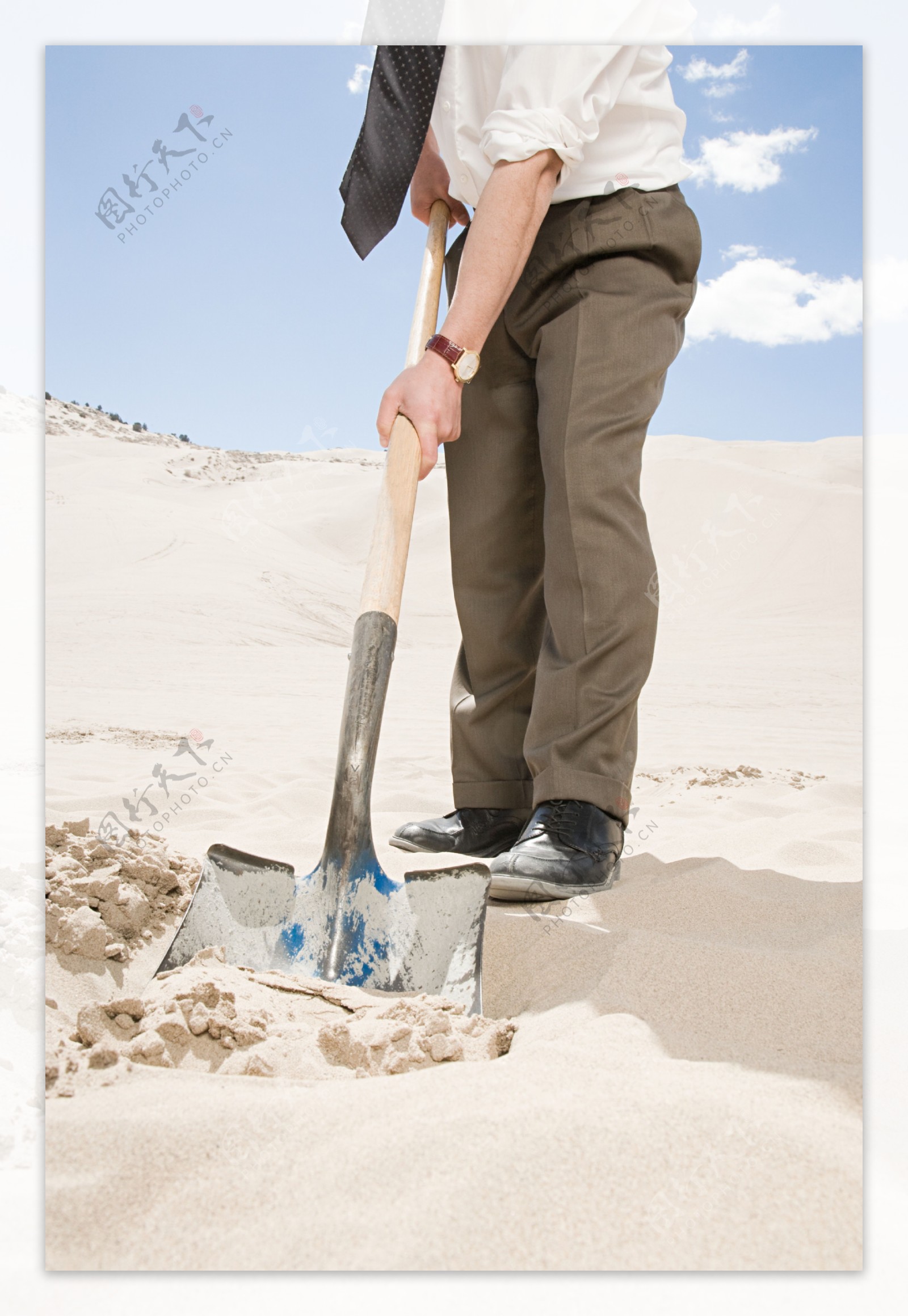 沙漠中铲沙子的男人图片