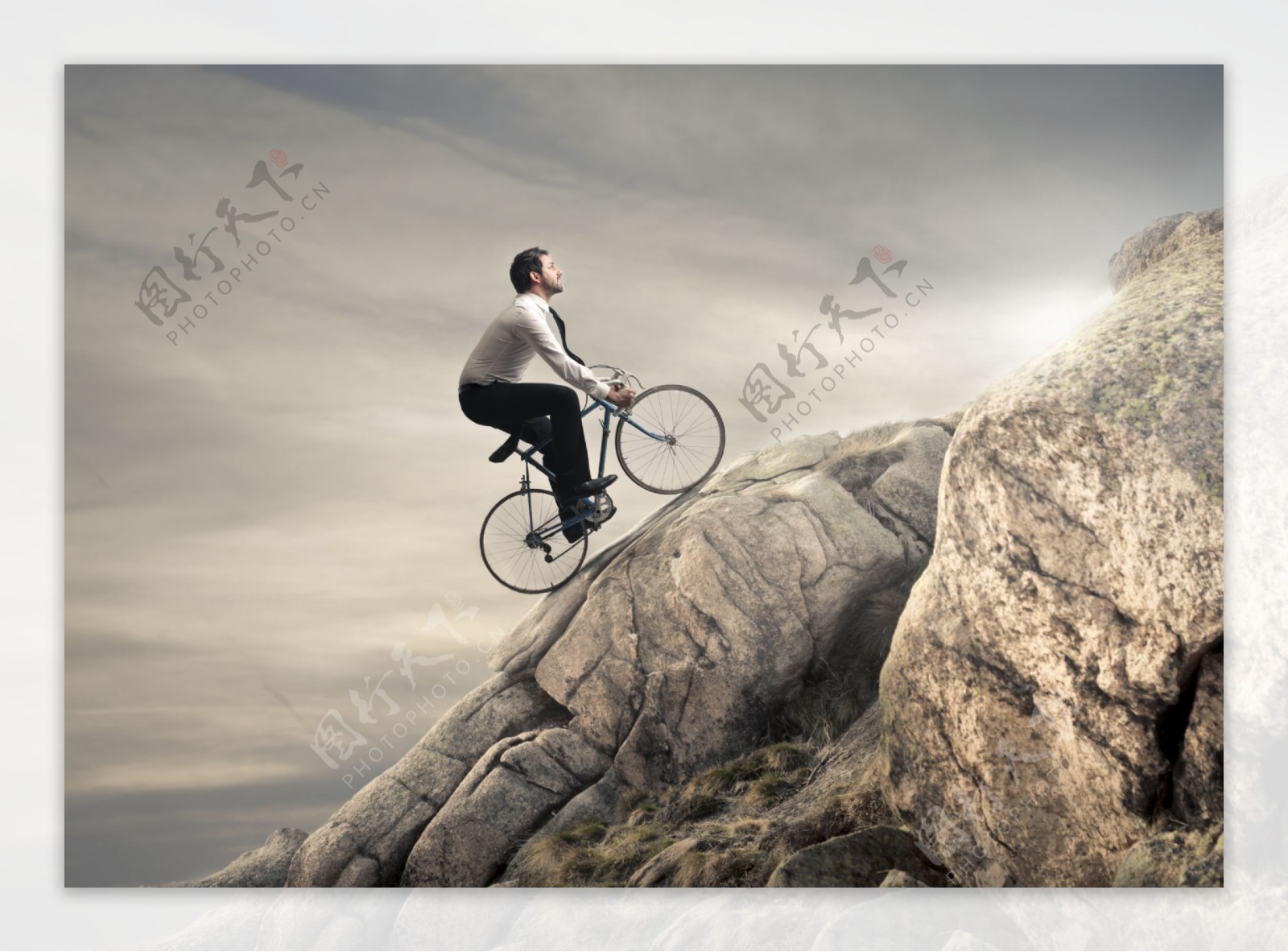 山坡上骑自行车的男人图片