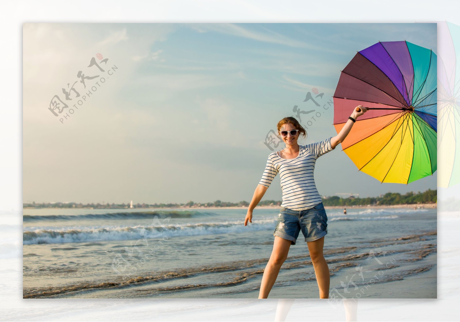 海滩打伞的时尚女性图片