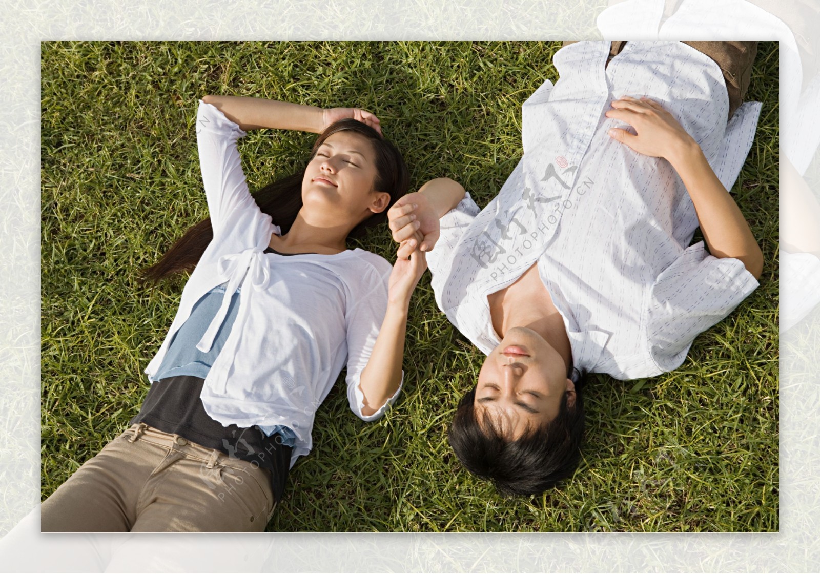 闭着眼睛躺在草地上牵着手的情侣图片图片