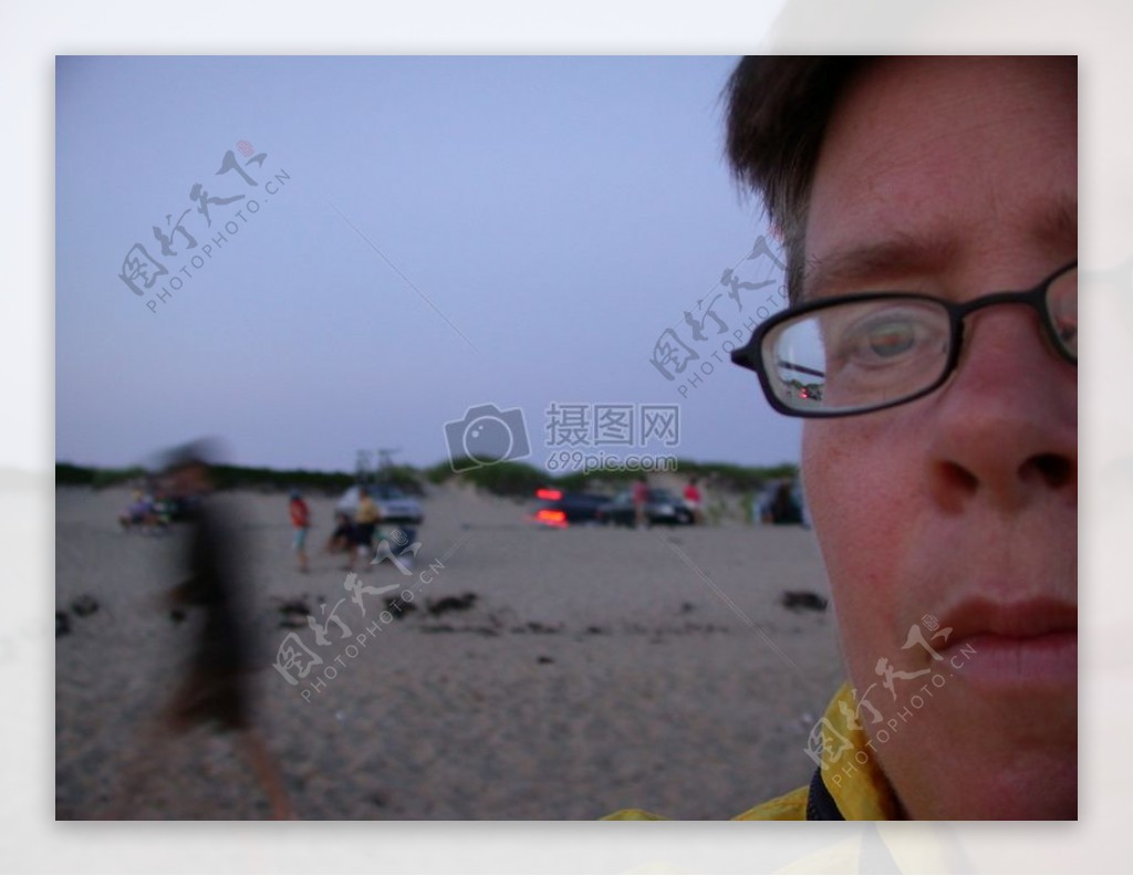 沙滩上戴眼镜的男性